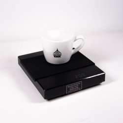 Timemore Black Mirror Basic Plus váha a na ní položen šálek na kávu.