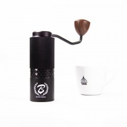 Barista Space ruční mlýnek na kávu s ocelovými kameny a šálek s logem Lázeňské kávy.