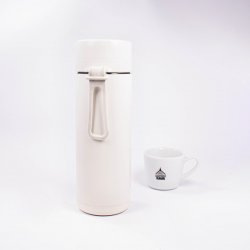 Keramická termoska ze zadní strany s lázeňskou kávou v pozadí