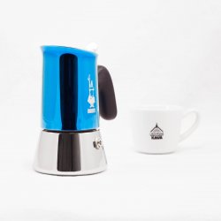 Bialetti New Venus v modré barvě pro 2 šálky kávy s lázeňskou kávou v pozadí.