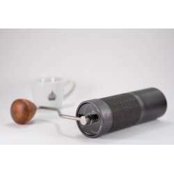 Ležící ruční mlýnek 1Zpresso J s detailem dřevěné ručky a espressem